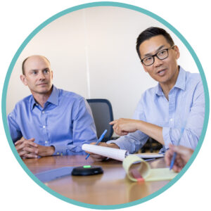 The Prothena team having a conversation at a table.