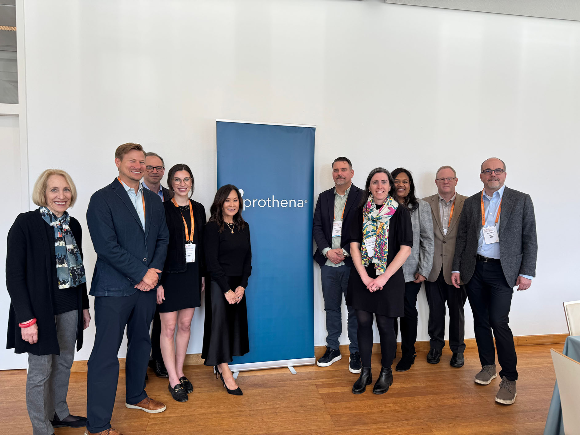 Members of the Prothena team standing in front of a banner at the annual International Conference on Alzheimer’s and Parkinson’s Diseases in Vienna, Austria.